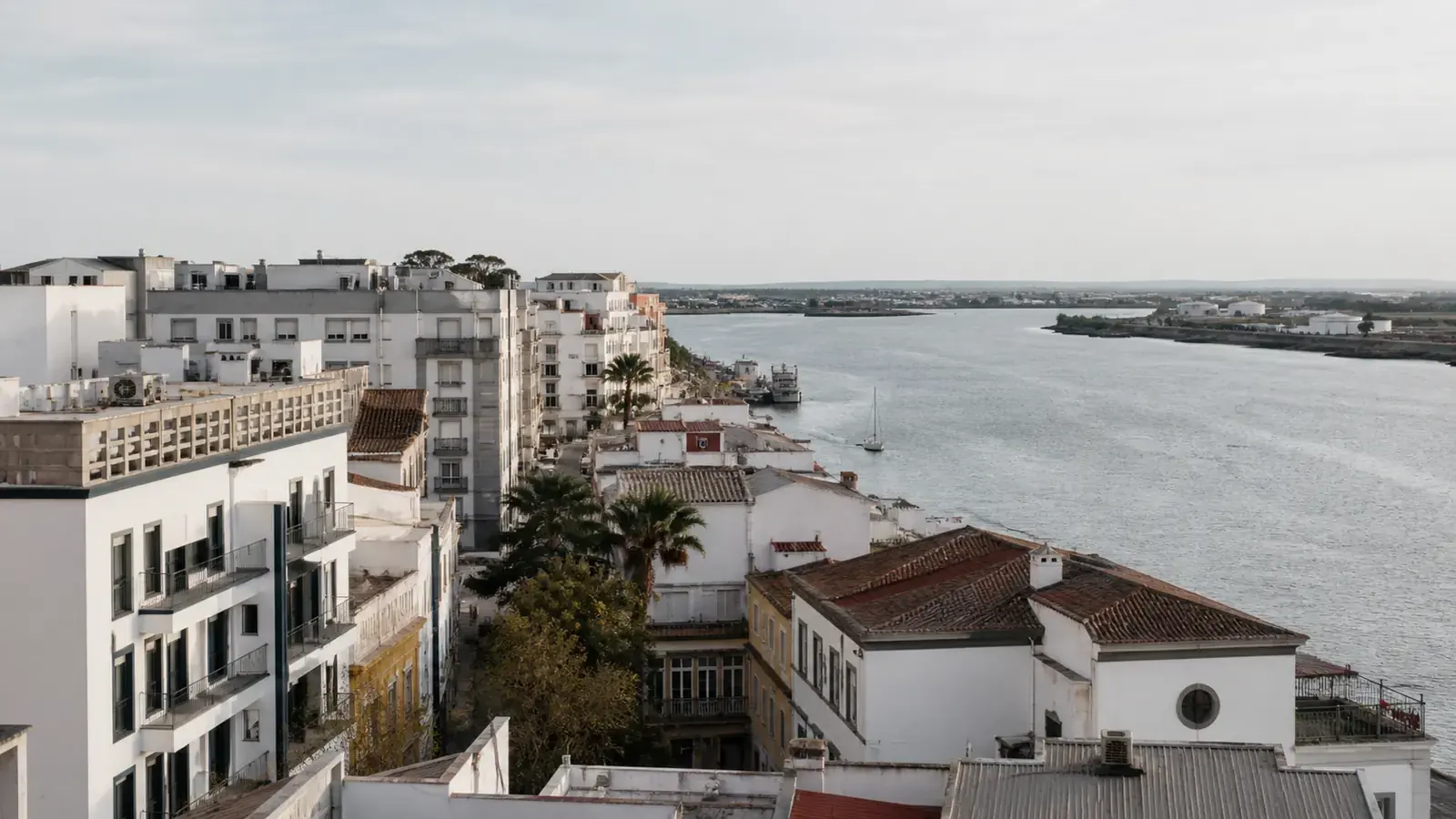 Edificios blancos junto a una ría con varias embarcaciones